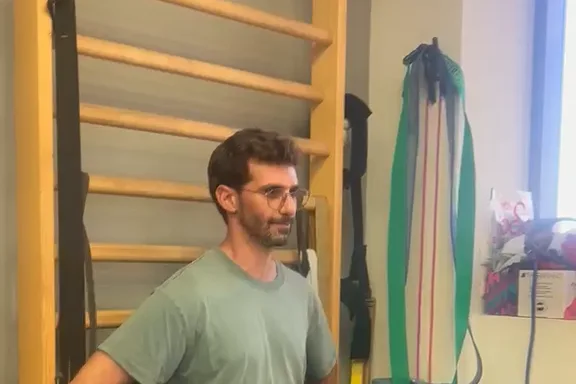 זיו ריחני בחדר הטיפולים, על רקע סולם שוודי ורצועות אימון